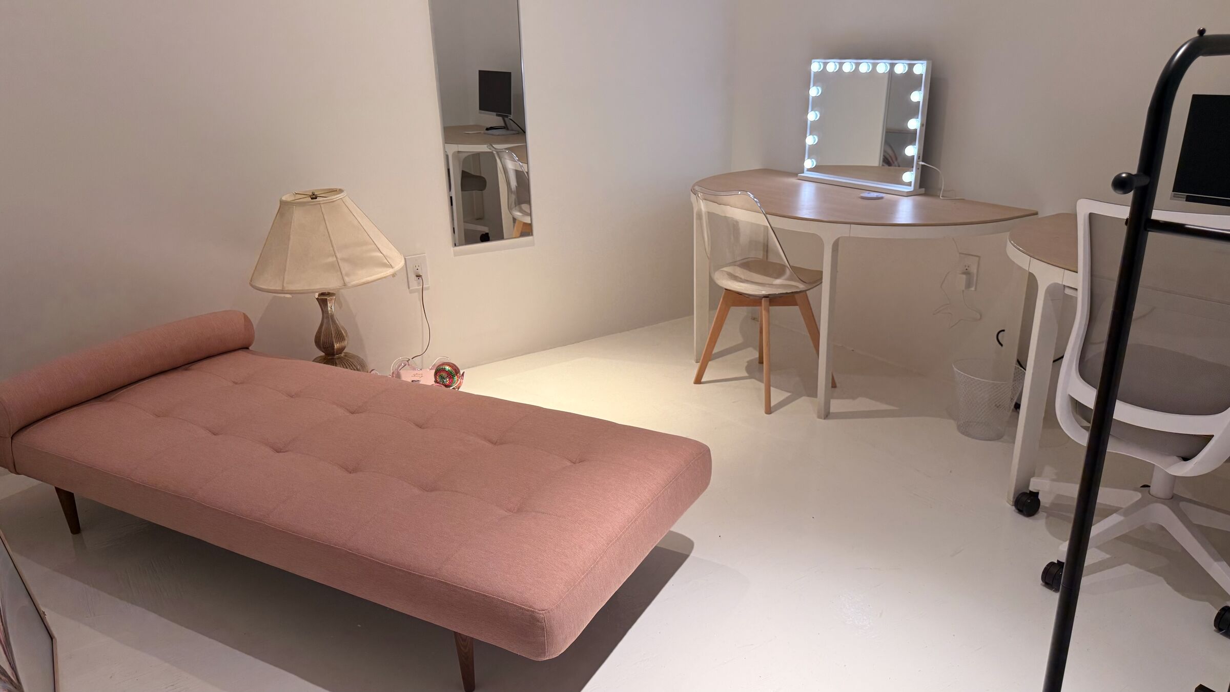 Makeup Studio: pink daybed, lit Hollywood-style vanity, half-moon desks with monitor, clothing rack, full-length mirror